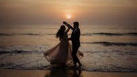 Romantic couple dancing on beach at sunset with golden sky and ocean waves, silhouetted against warm evening light for wedding and love concepts.