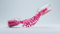 Glass test tube spilling pink pills or capsules on white background for medical pharmaceutical research and healthcare concepts.