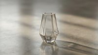 Empty geometric glass vase with faceted sides casting shadows on concrete surface, suitable for product photography and interior design projects.