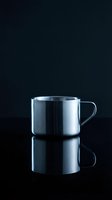 Stainless steel camping mug with handle isolated on dark background, ready for beverage product mockups and kitchenware design projects.