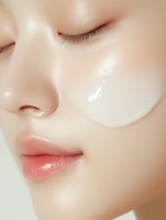 Close-up of young woman applying transparent facial serum or moisturizer on glowing skin for skincare routine and beauty treatment.