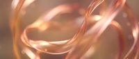 Flowing copper ribbons with metallic shine creating elegant abstract curves and swirls in warm golden light for luxury design and modern art projects.