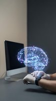 Holographic brain projection floating above hands with computer in background representing artificial intelligence and neural network technology.
