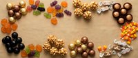 Assorted Halloween candy and chocolates arranged in decorative border on kraft paper background for seasonal treats and holiday celebrations.