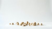Natural wooden beads scattered on white surface creating minimalist composition for craft projects and jewelry making supplies display.