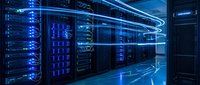 Modern data center with illuminated server racks and blue neon lighting, showcasing advanced computing infrastructure for cloud storage and network technology.