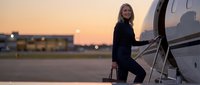 Professional businesswoman boarding private jet at sunset airport for luxury corporate travel and executive lifestyle.