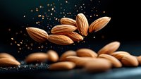 Flying almonds with spices and powder on dark background, dramatic food photography with levitation effect and motion blur for culinary projects.