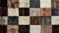 Patchwork fur texture background with various animal hide squares in brown, beige, gray and white tones for luxury interior design and fashion projects.