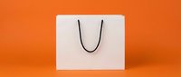 White shopping bag with black handles isolated on vibrant orange background, ready for retail branding, packaging design, and commercial use.