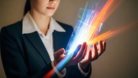 Professional businesswoman holding glowing digital light beams with colorful energy streams for technology and innovation concepts.