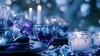 Elegant crystal glasses and candle holder with soft bokeh lights in blue tones create romantic winter holiday atmosphere for festive table decoration.
