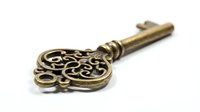 Ornate brass skeleton key with decorative filigree head isolated on white background, suitable for vintage design, antique decor, steampunk projects, and historical illustrations.