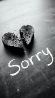 Broken heart on dark chalkboard with Sorry written in chalk, black and white emotional concept of apology, regret, and reconciliation.