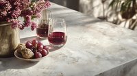 Elegant marble countertop with red wine glasses, fresh grapes, artisan bread, and lilac flowers in gold vase, perfect for food and lifestyle content.
