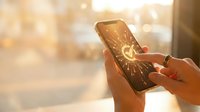 Female hands holding smartphone with glowing lightbulb icon on cracked screen representing innovation and creative ideas in warm sunlight.