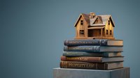 Wooden house model sitting on stack of law books including property law and architecture titles for real estate education and legal studies.