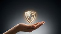Glowing shield icon floating above open palm against dark background, representing security, protection, and digital safety for web design and technology concepts.