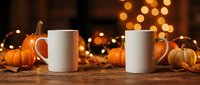Blank white mugs mockup with autumn pumpkins and warm bokeh lights on wooden surface for seasonal marketing and product display.