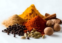 Colorful aromatic spices collection with turmeric, paprika, cinnamon, nutmeg, cardamom, and black pepper on white background for cooking and food photography.