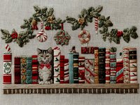 Festive embroidery of tabby cat with red bow tie sitting on bookshelf with Christmas books, decorated with pine garland, ornaments, and candy canes.