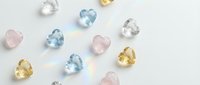 Colorful gemstones collection featuring blue topaz, rose quartz, citrine and clear crystals scattered on white background for jewelry design projects.