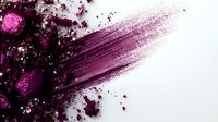 Purple makeup powder explosion with brush stroke and scattered particles on white background for cosmetic beauty advertising campaigns.
