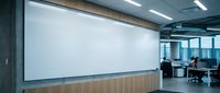Modern office conference room with large blank white projection screen on wall ready for presentations and meetings in corporate workspace environment.
