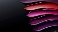 Vibrant purple and red flower petals arranged in curved layers against dark background create dramatic contrast and abstract organic composition.