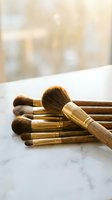 Professional makeup brushes with wooden handles and golden ferrules arranged on marble surface for beauty and cosmetics applications.