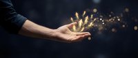 Male hand releasing golden light particles and sparkling magic dust against dark background, representing success, growth, innovation, and digital transformation for business concepts.