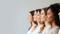 Diverse group of young women in profile view smiling together representing unity, teamwork and female empowerment in modern workplace or social setting.