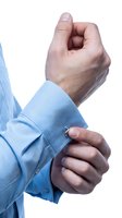 Male hand in light blue shirt cuff adjusting sleeve, showing gesture of professionalism and attention to detail for business and corporate contexts.