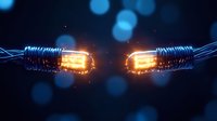 Glowing optical fiber cables with orange light breaking apart against dark background with bokeh effect, representing digital communication disruption.