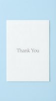 Minimalist thank you card with elegant serif text on white paper, placed on a soft blue background for greeting and stationery design.