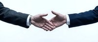 Business handshake between two professionals in dark suits on white background symbolizing partnership, agreement, and successful deal completion.