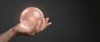 Hand holding glowing pink crystal sphere with mystical energy effects against dark background for spiritual healing and meditation concepts.