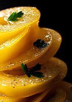 Fresh yellow peach slices stacked in layers with parsley leaves and water drops on black background, macro food photography for restaurant menu design.