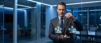Professional businessman in suit holding scales of justice in modern office with blue lighting representing legal services and corporate law consulting.