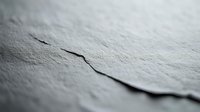 Cracked concrete surface with deep fissure showing weathered texture and structural damage for construction and repair concepts.
