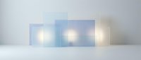 Translucent glass panels with glowing light sources creating modern geometric composition on white surface for contemporary design projects.