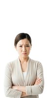 Asian woman with dark hair and fair complexion, wearing a beige cardigan over a white top, standing against a white background with arms crossed and a serious, displeased expression, suitable for business, corporate, and emotional concept use.