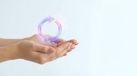 Hand holding glowing purple circular arrow symbol representing renewal, sustainability, and recycling concept for eco-friendly business solutions.