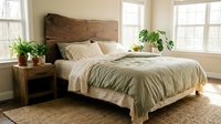Cozy modern bedroom interior with wooden headboard, neutral bedding, houseplants and natural light creating peaceful sleeping space for home decor.