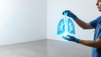 Male doctor in blue scrubs holding glowing holographic lungs projection for medical diagnosis and respiratory health examination in modern clinic.