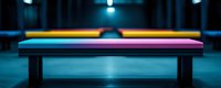 Colorful rainbow bench against dark moody background with dramatic lighting creates striking contrast, suitable for themes of diversity, hope and urban design.