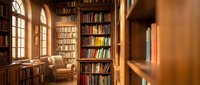 Cozy home library with floor-to-ceiling bookshelves, comfortable reading chair and warm natural lighting from arched windows creating scholarly atmosphere.