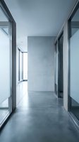 Modern minimalist office corridor with glass walls and concrete floors in contemporary commercial building for corporate interior design projects.