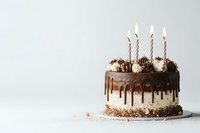 Chocolate drip cake with whipped cream frosting and lit birthday candles on white background. Minimalist celebration dessert with copy space.