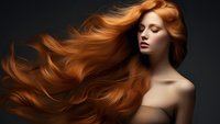 Young woman with flowing red hair against dark background, closed eyes and bare shoulders, dramatic fashion portrait showcasing long wavy hairstyle in motion.